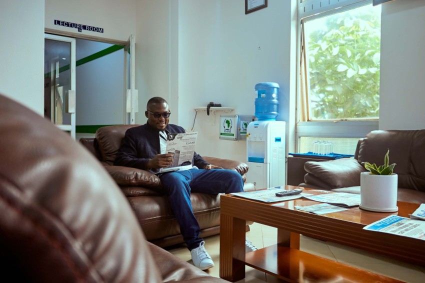 handsome young african man reading a publication at the living area